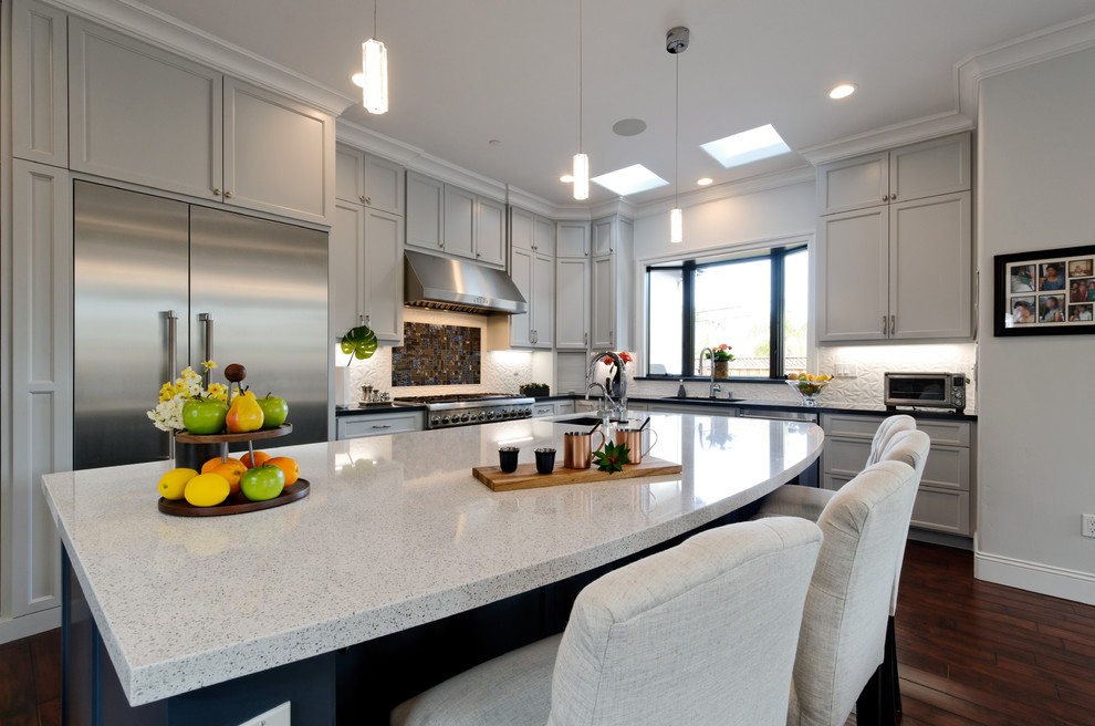 Example of a large transitional u-shaped dark wood floor and brown floor eat-in kitchen design in San Francisco with an undermount sink, recessed-panel cabinets, gray cabinets, quartz countertops, white backsplash, ceramic backsplash, stainless steel appliances, an island and white countertops