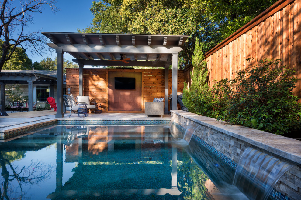 This is an example of a mid-sized contemporary backyard pool in Dallas.