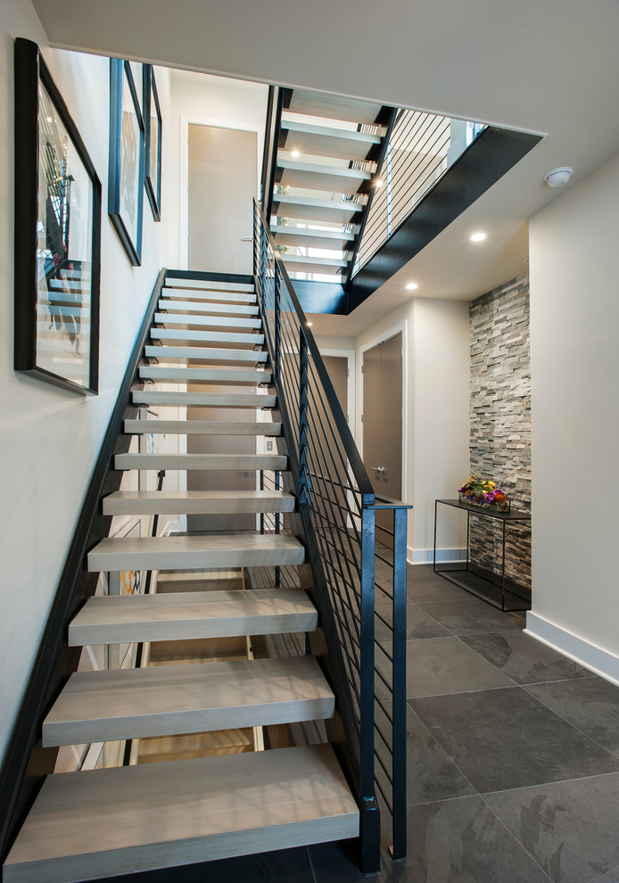 Large modern concrete floating staircase in Philadelphia with metal railing.