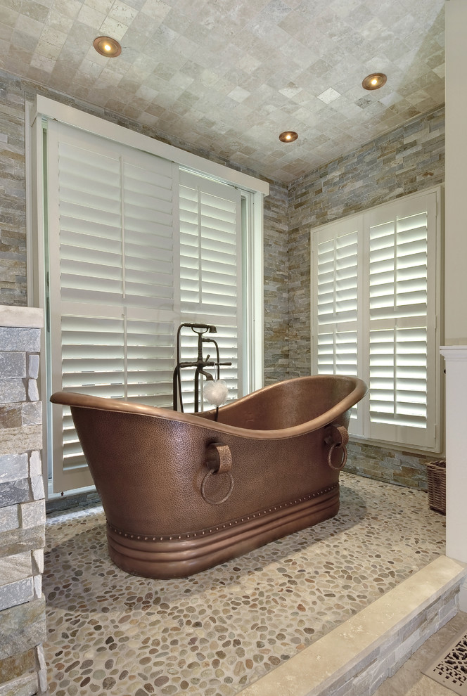 Design ideas for a large transitional master bathroom in Charleston with recessed-panel cabinets, beige cabinets, a freestanding tub, a corner shower, gray tile, stone tile, beige walls, porcelain floors, a vessel sink, beige floor and a hinged shower door.