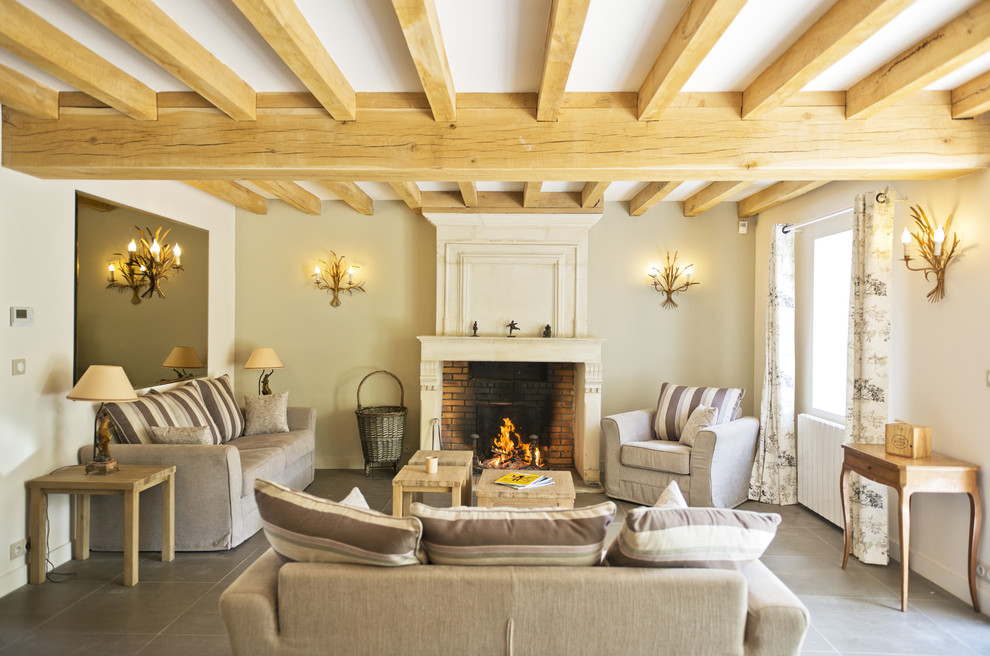 Large country formal enclosed living room in Paris with beige walls, a standard fireplace, a brick fireplace surround, ceramic floors and no tv.