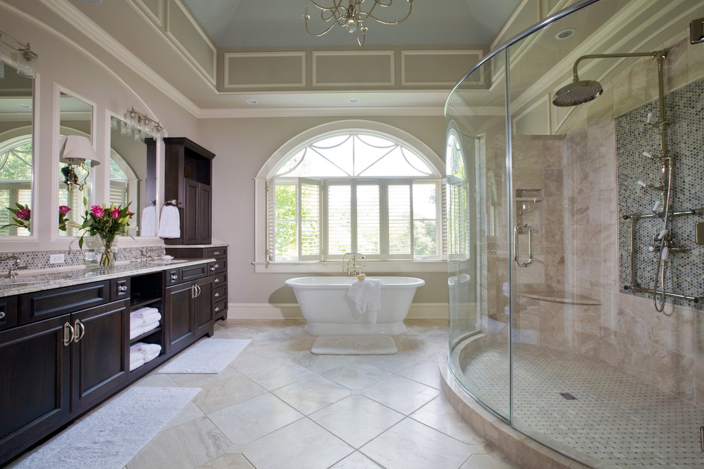 Expansive traditional master bathroom in Baltimore with an undermount sink, recessed-panel cabinets, dark wood cabinets, a freestanding tub, beige tile, porcelain tile, grey walls, travertine floors, granite benchtops and an alcove shower.