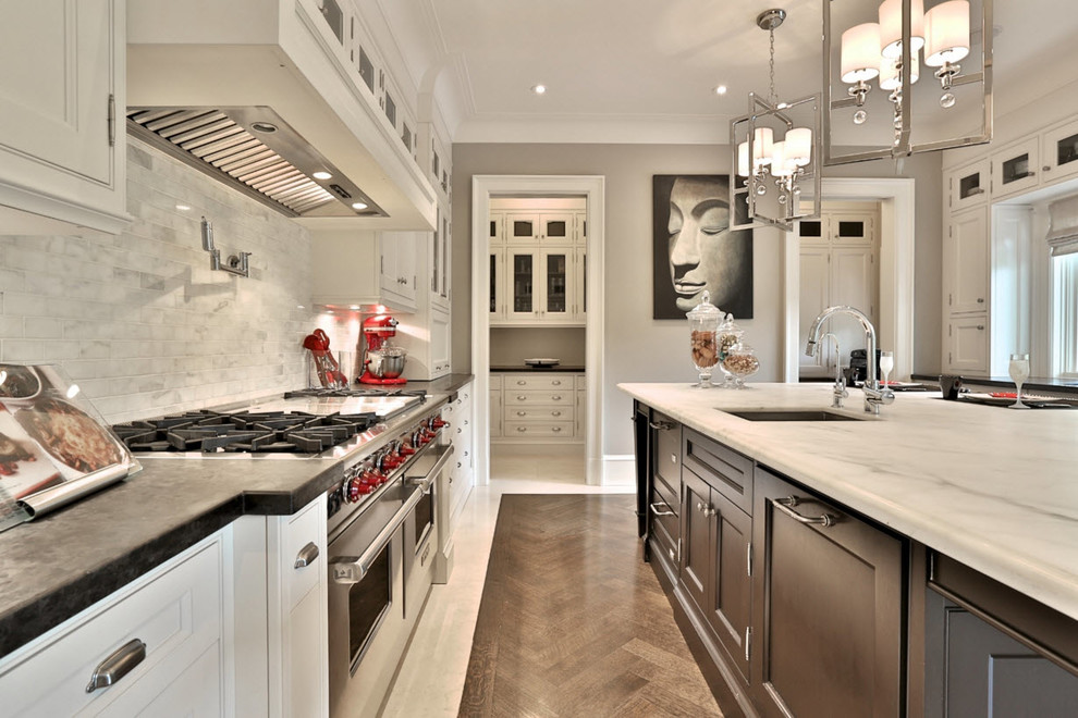 Inspiration for a large transitional medium tone wood floor and brown floor kitchen remodel in Toronto with an undermount sink, recessed-panel cabinets, dark wood cabinets, marble countertops, gray backsplash, marble backsplash, stainless steel appliances and an island