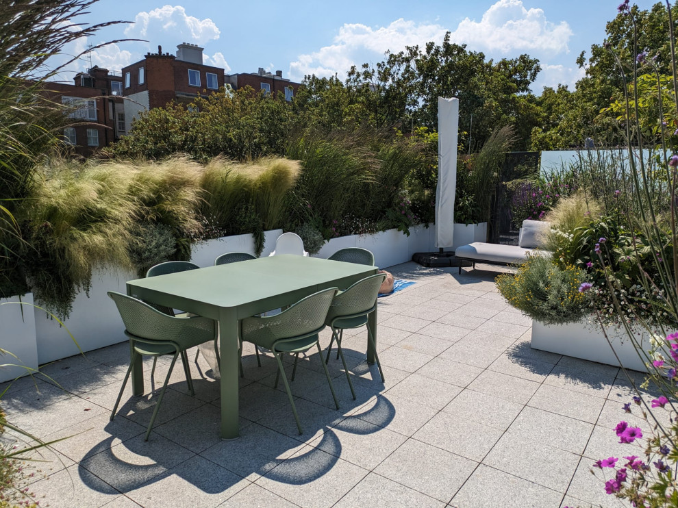 Foto di un orto rialzato design esposto in pieno sole di medie dimensioni e sul tetto in estate con pavimentazioni in pietra naturale e recinzione in metallo