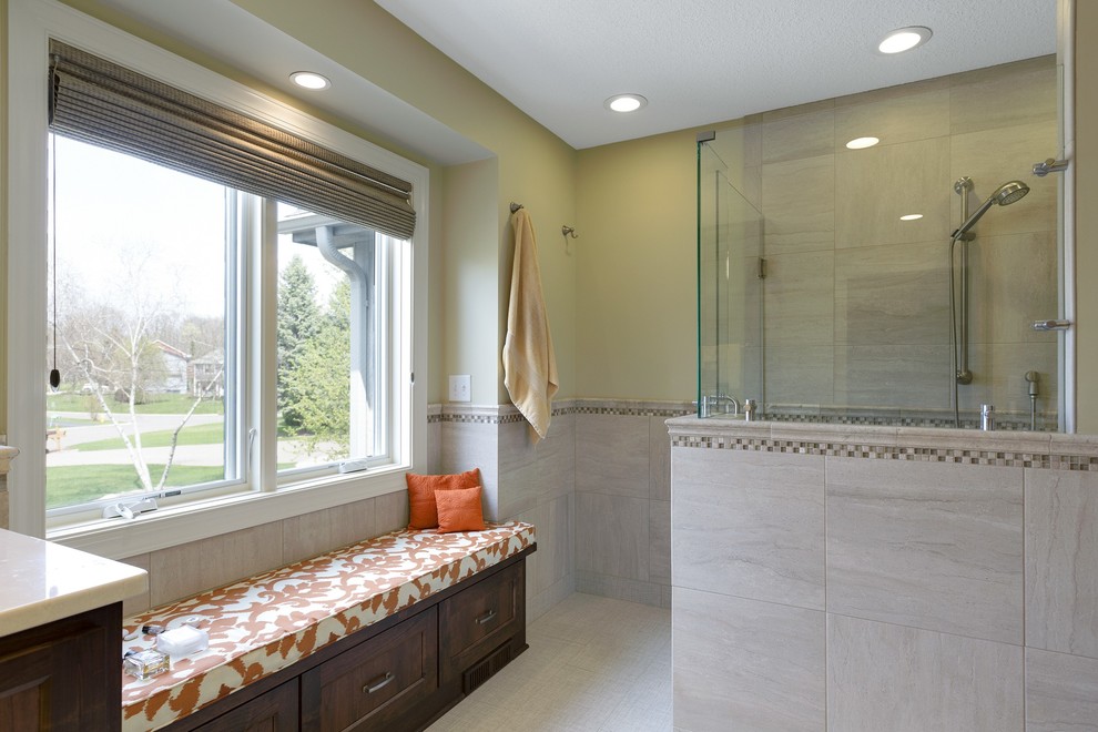 This is an example of a large transitional master bathroom in Minneapolis with shaker cabinets, dark wood cabinets, a curbless shower, a one-piece toilet, beige tile, ceramic tile, beige walls, ceramic floors, an undermount sink and engineered quartz benchtops.