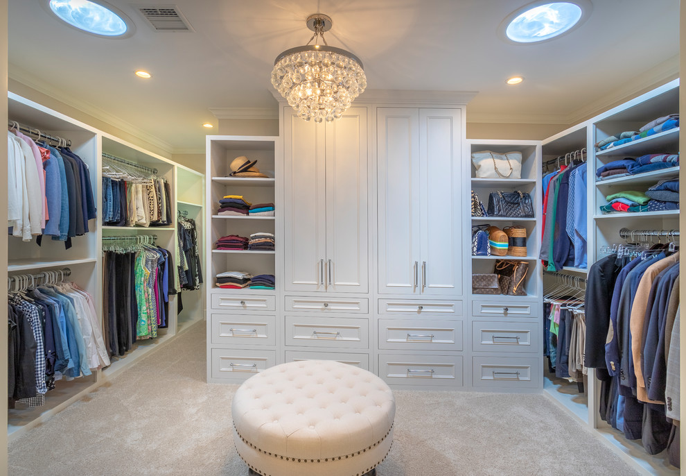 Inspiration for a large transitional dressing room in Los Angeles with recessed-panel cabinets, white cabinets, carpet and beige floor.