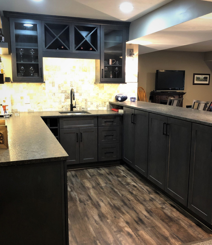 Photo of a small country u-shaped wet bar in Other with an undermount sink, flat-panel cabinets, dark wood cabinets, granite benchtops, grey splashback, travertine splashback, vinyl floors, brown floor and brown benchtop.
