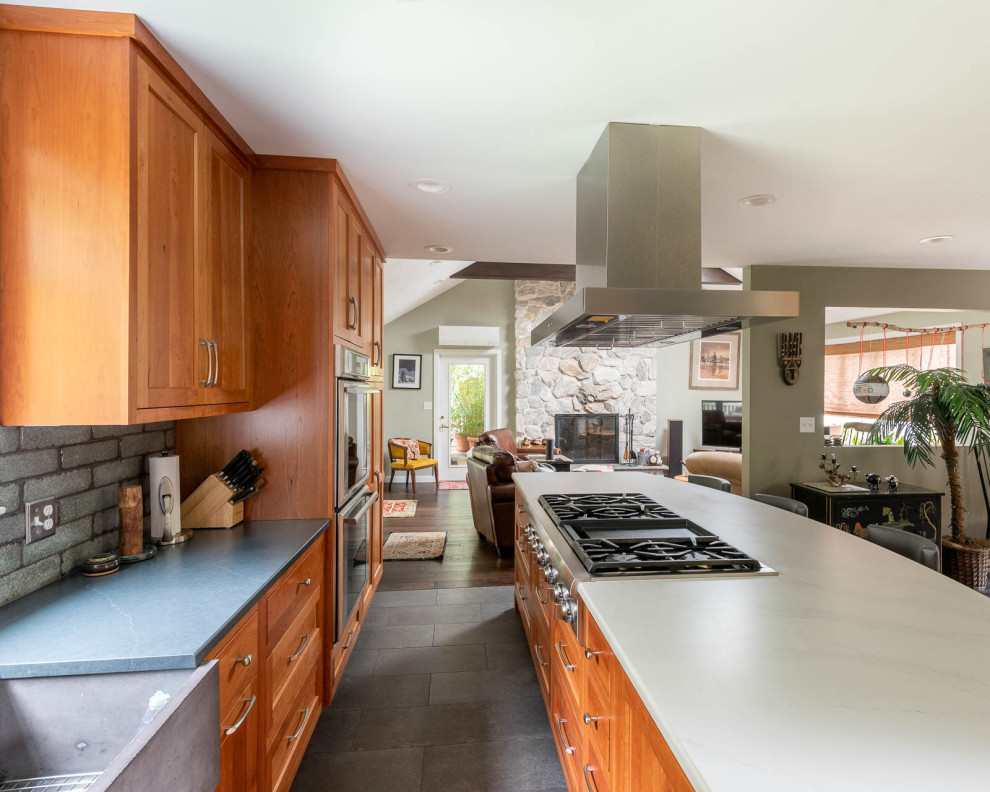 Eat-in kitchen - large transitional l-shaped porcelain tile and gray floor eat-in kitchen idea in Boston with a farmhouse sink, shaker cabinets, medium tone wood cabinets, quartz countertops, gray backsplash, porcelain backsplash, stainless steel appliances, an island and white countertops
