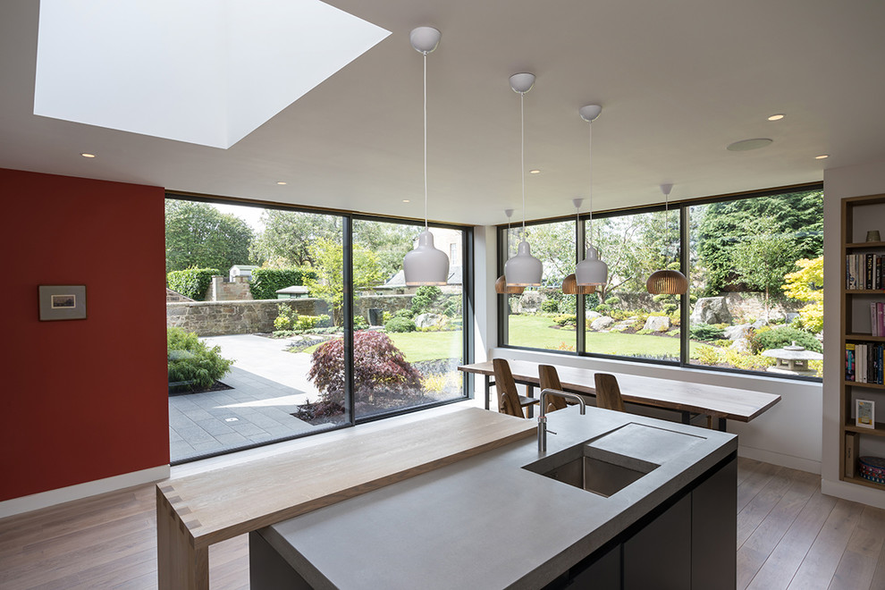Inspiration for a large asian eat-in kitchen in Edinburgh with an undermount sink, flat-panel cabinets, white cabinets, stainless steel appliances, light hardwood floors, with island and beige floor.
