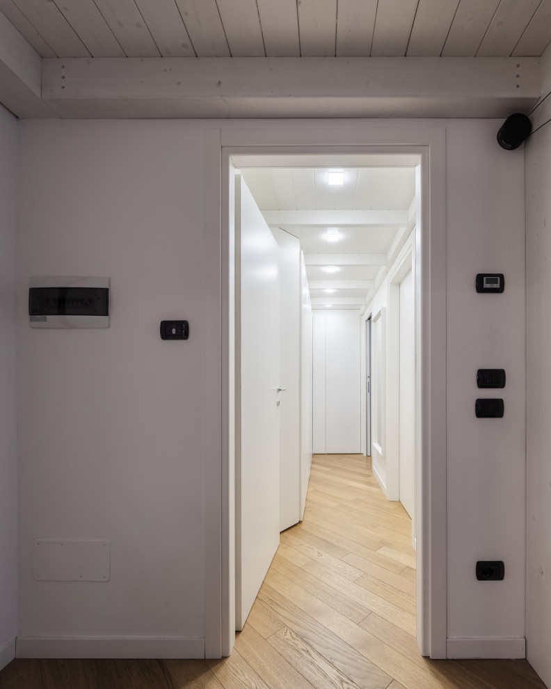 Свежая идея для дизайна: маленький коридор в скандинавском стиле с белыми стенами, полом из ламината, коричневым полом и деревянным потолком для на участке и в саду - отличное фото интерьера