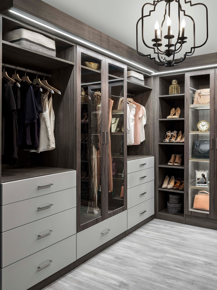 Photo of a mid-sized transitional gender-neutral walk-in wardrobe in New York with flat-panel cabinets, grey cabinets and grey floor.