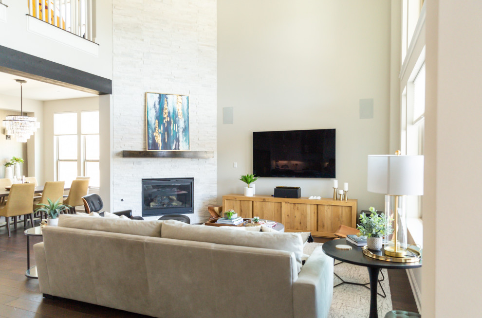 Großes, Offenes Klassisches Wohnzimmer mit grauer Wandfarbe, braunem Holzboden, Eckkamin, Kaminumrandung aus Stein, TV-Wand, braunem Boden und Kassettendecke in Austin