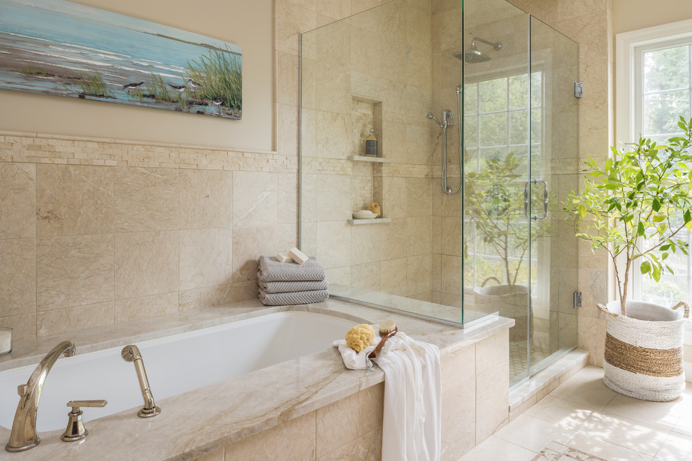 Photo of a large mediterranean master bathroom in St Louis with raised-panel cabinets, beige cabinets, an undermount tub, a corner shower, a two-piece toilet, beige tile, marble, beige walls, marble floors, an undermount sink, marble benchtops, beige floor, a hinged shower door and beige benchtops.