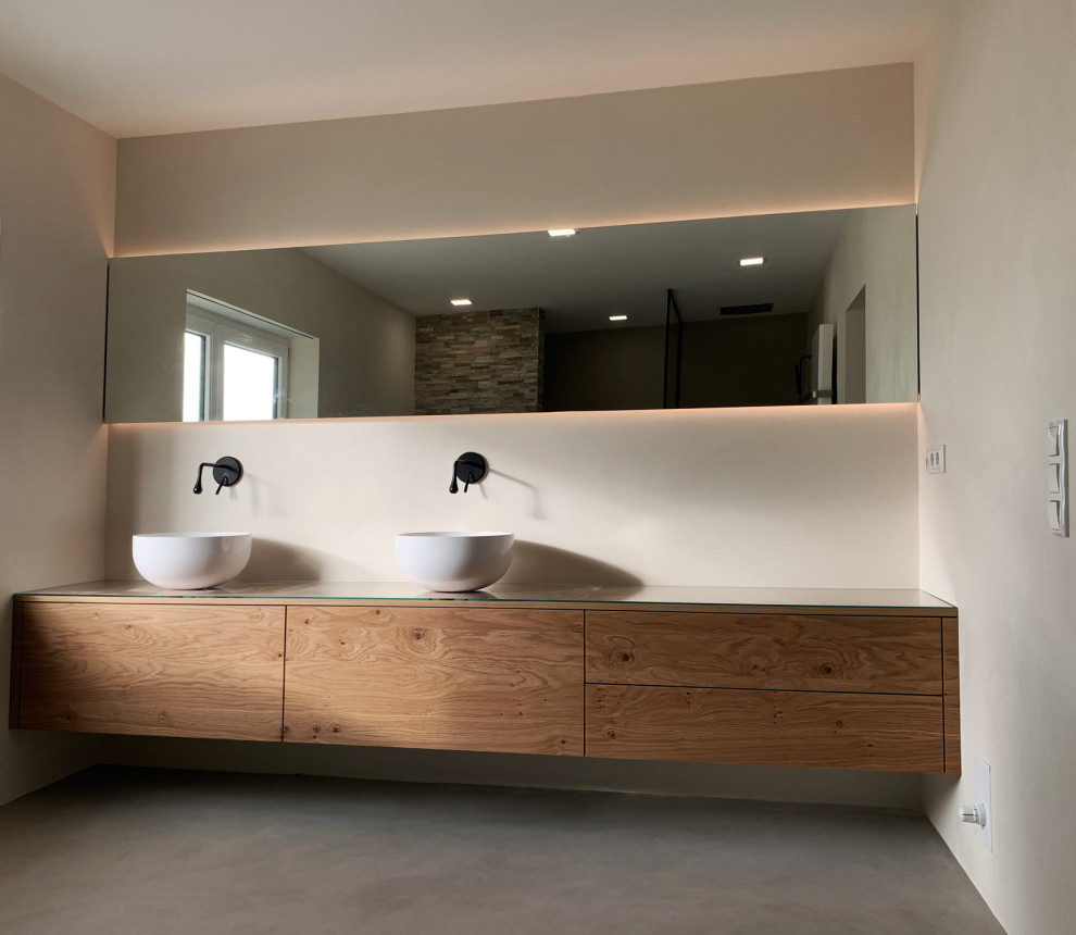 Inspiration for a large contemporary 3/4 bathroom in Nuremberg with medium wood cabinets, a freestanding tub, a curbless shower, a wall-mount toilet, yellow walls, concrete floors, a vessel sink, wood benchtops, grey floor, an open shower, white benchtops, a niche, a double vanity, a freestanding vanity and wallpaper.