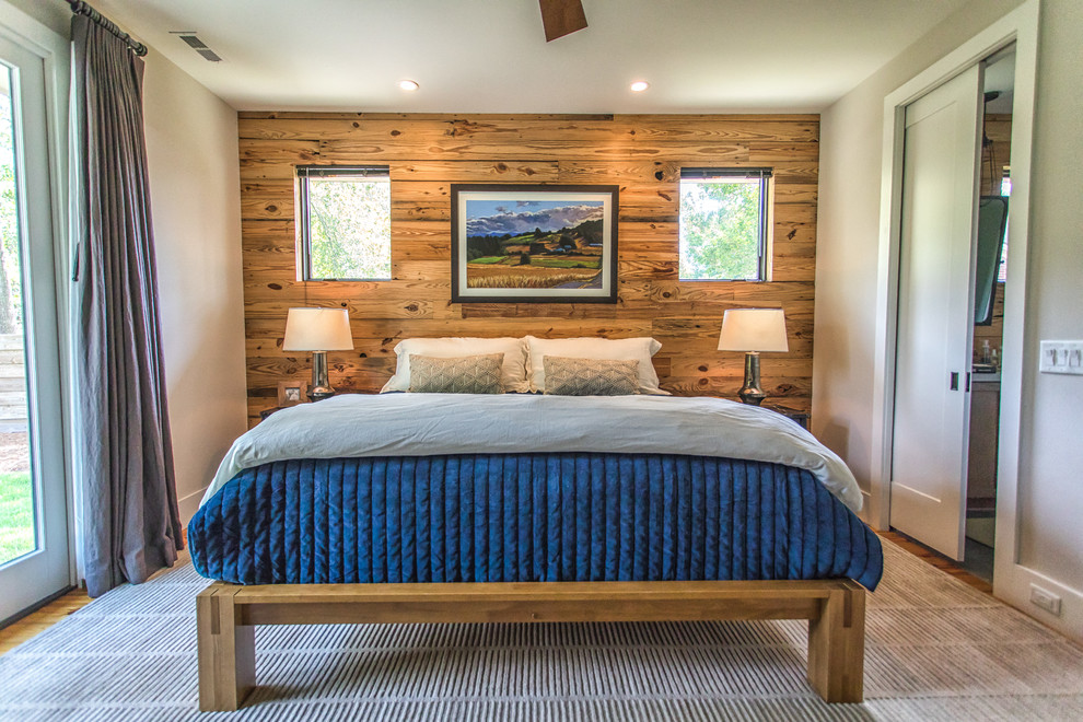 Country bedroom in Other with black walls, medium hardwood floors and brown floor.