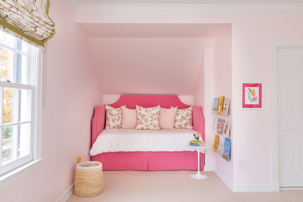This is an example of a large transitional bedroom in New York with pink walls, carpet and beige floor.