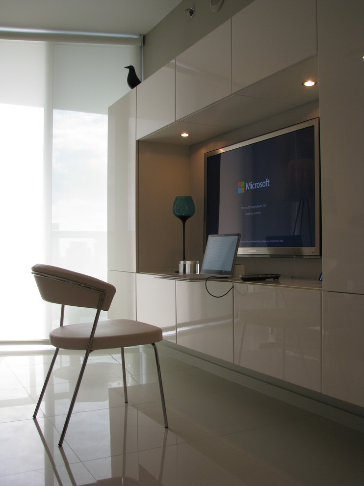 Large modern home office in Miami with white walls, porcelain floors and no fireplace.