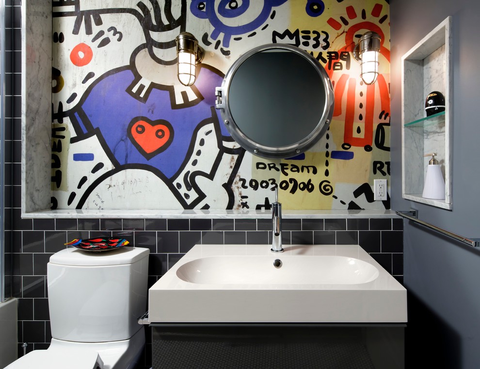 Photo of a mid-sized contemporary kids bathroom in Toronto with flat-panel cabinets, grey cabinets, an alcove tub, a shower/bathtub combo, a two-piece toilet, black tile, porcelain tile, multi-coloured walls, porcelain floors and an integrated sink.