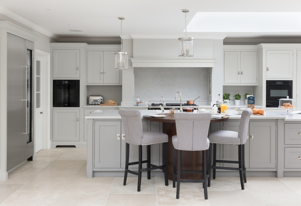 This is an example of a large transitional l-shaped kitchen in Other with recessed-panel cabinets, grey cabinets, wood benchtops, black appliances, with island, beige floor and brown benchtop.