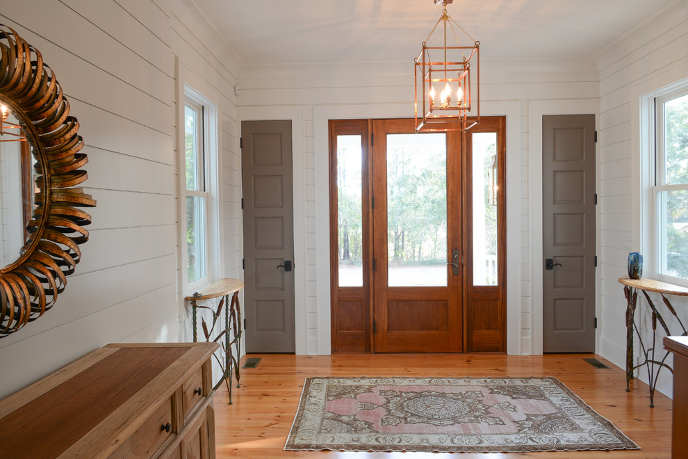 Design ideas for a mid-sized country foyer in Charleston with white walls, light hardwood floors, a single front door, a dark wood front door and brown floor.