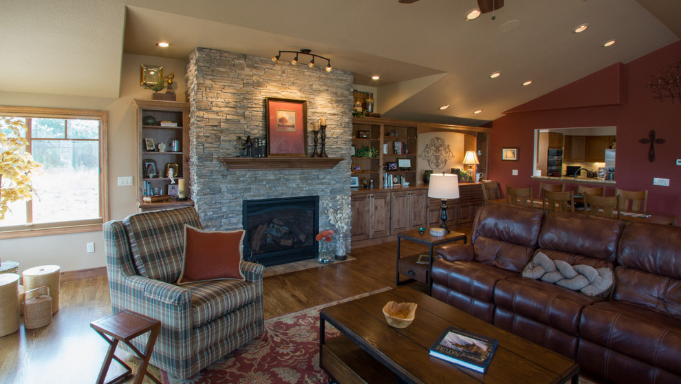 Inspiration for a large traditional open concept family room in Denver with brown walls, medium hardwood floors, a standard fireplace, a stone fireplace surround and a built-in media wall.
