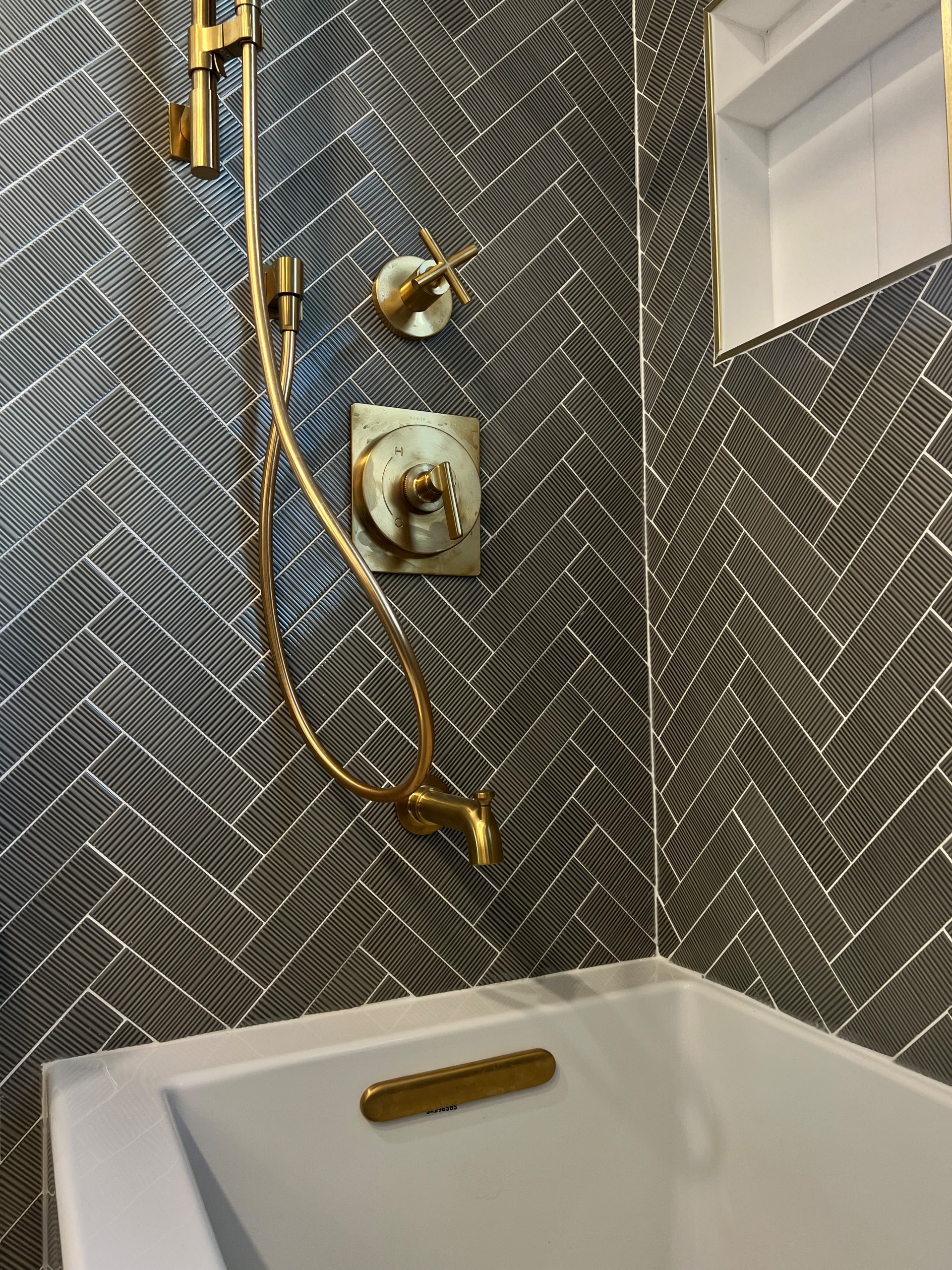 Transitional Primary Bathroom Renovation with herringbone ribbed tile, double vanity sink, and checkered flooring.