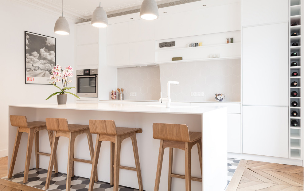 Cuisine?[Exemple de cuisine With un sol beige, un évier intégré, un placard à porte affleurante, des portes de placard blanches, un plan de travail en surface solide, une crédence beige, une crédence en céramique, un électroménager blanc, parquet clair, îlot and un plan de travail blanc.]:[Exemple de cuisines With un sol beige, un évier intégré, un placard à porte affleurante, des portes de placard blanches, un plan de travail en surface solide, une crédence beige, une crédence en céramique, un électroménager blanc, parquet clair, îlot and un plan de travail blanc.]