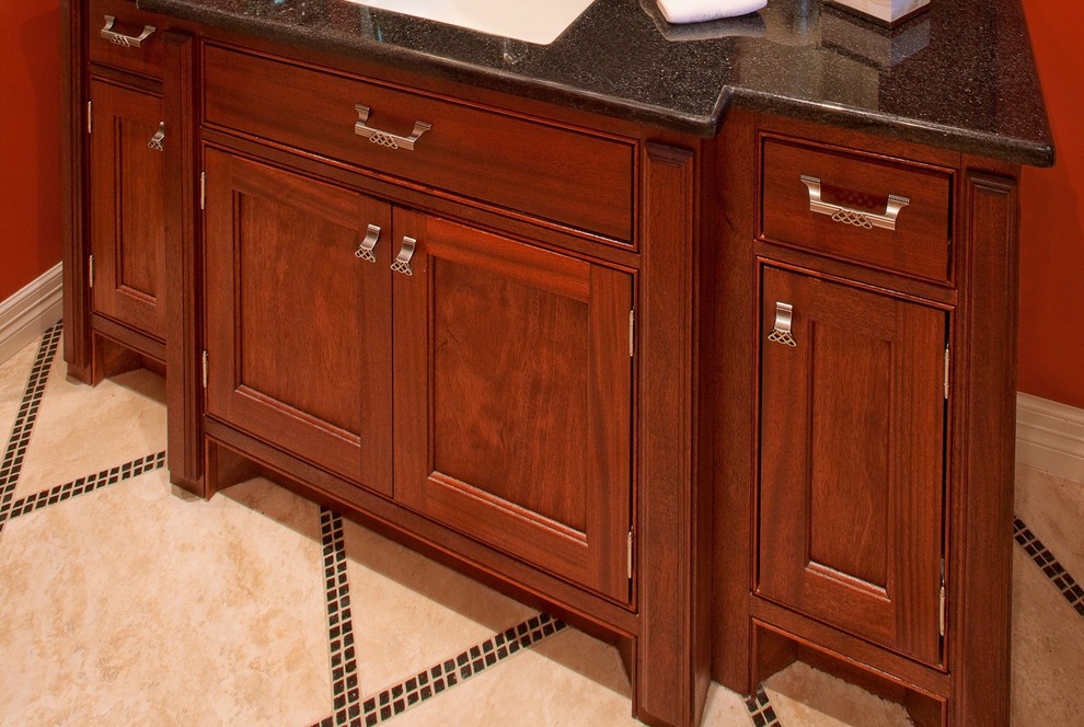 Photo of a large arts and crafts bathroom in Houston with furniture-like cabinets, medium wood cabinets, granite benchtops, an alcove shower, beige tile, travertine floors, a bidet, porcelain tile, orange walls and an undermount sink.