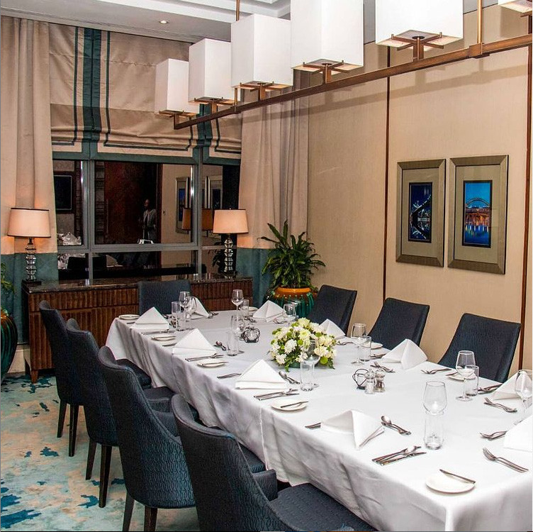 Example of a transitional carpeted, turquoise floor, tray ceiling and wall paneling dining room design