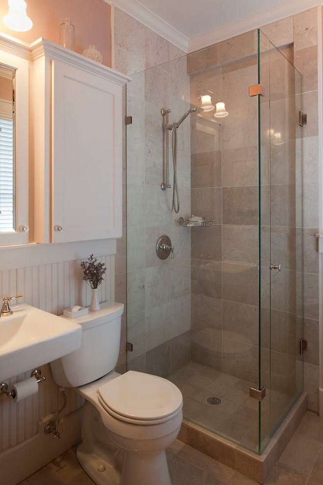 This is an example of a small traditional 3/4 bathroom in Austin with shaker cabinets, white cabinets, a corner shower, a two-piece toilet, beige tile, beige walls, travertine floors, a wall-mount sink and a hinged shower door.