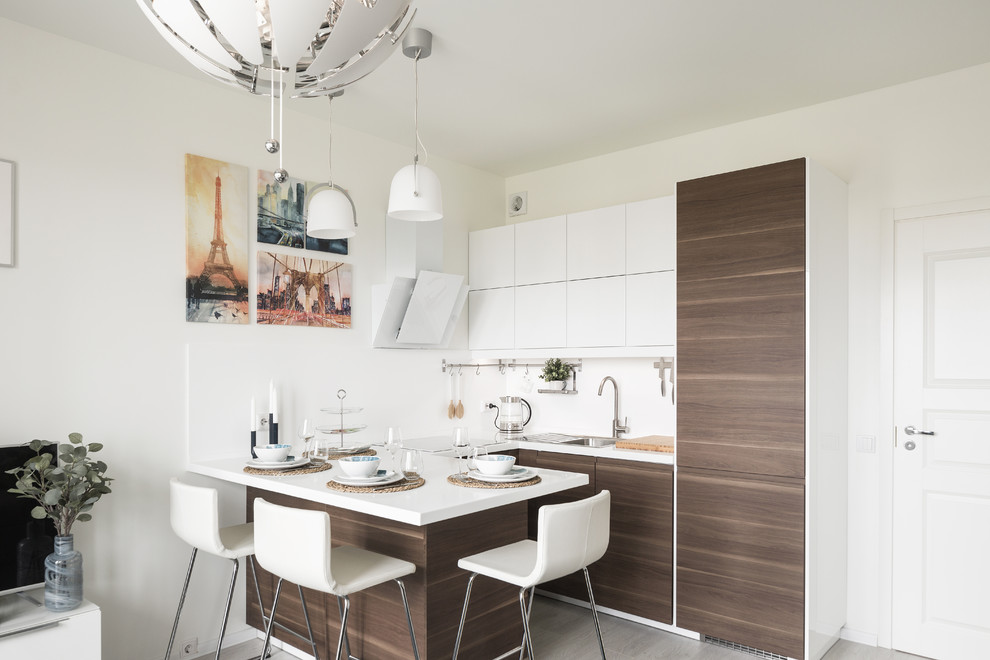 This is an example of a small contemporary u-shaped open plan kitchen in Saint Petersburg with a drop-in sink, flat-panel cabinets, dark wood cabinets, a peninsula, grey floor, white benchtop, white splashback, stone tile splashback and laminate floors.