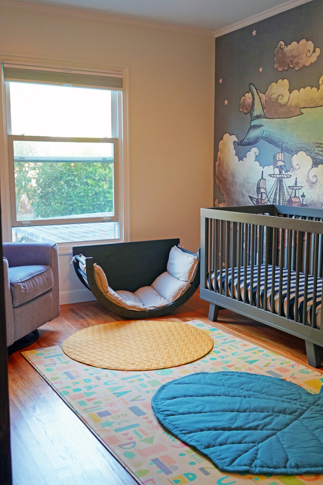 Cette photo montre une petite chambre d'enfant de 1 à 3 ans moderne avec parquet clair et du papier peint.