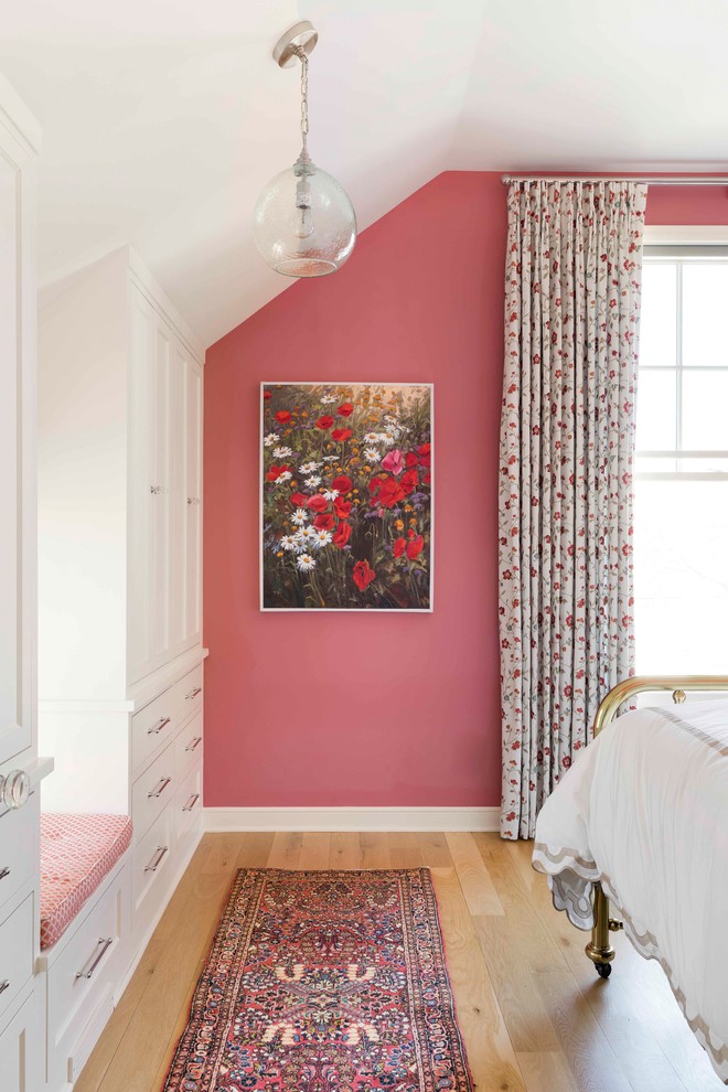 This is an example of a transitional bedroom in Minneapolis with pink walls and light hardwood floors.