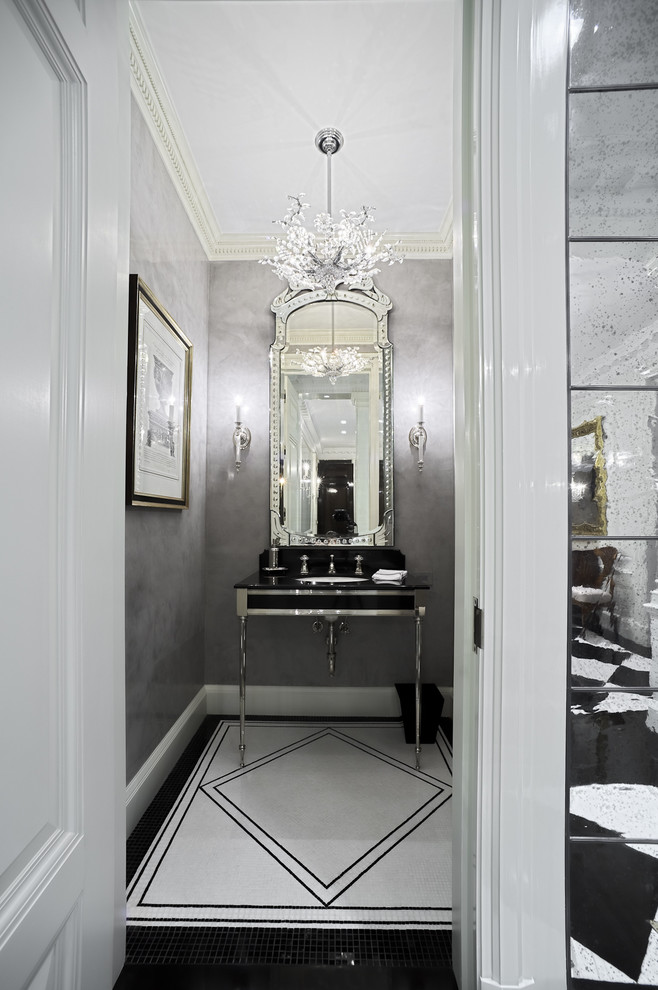 Photo of a small traditional powder room in New York with an undermount sink, grey walls and black and white tile.