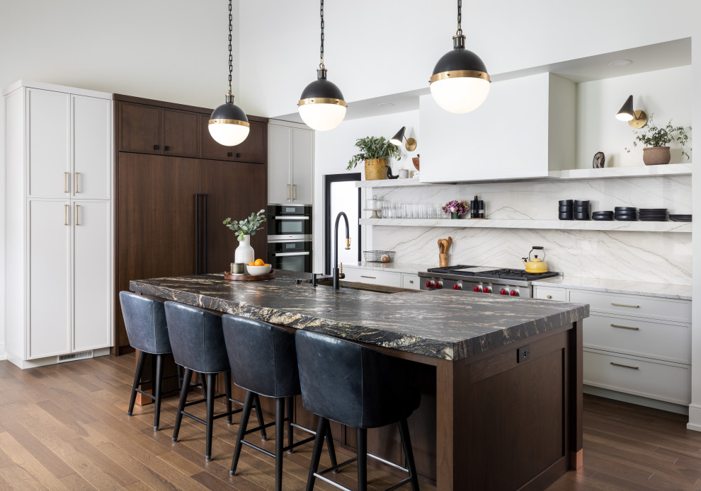 Inspiration for a classic l-shaped open plan kitchen in Detroit with a belfast sink, white splashback, integrated appliances, dark hardwood flooring, an island, brown floors, white worktops, shaker cabinets and white cabinets.