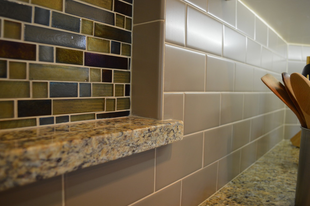 Mid-sized elegant u-shaped ceramic tile and brown floor open concept kitchen photo with an undermount sink, beaded inset cabinets, white cabinets, granite countertops, gray backsplash, subway tile backsplash, stainless steel appliances, an island and gray countertops