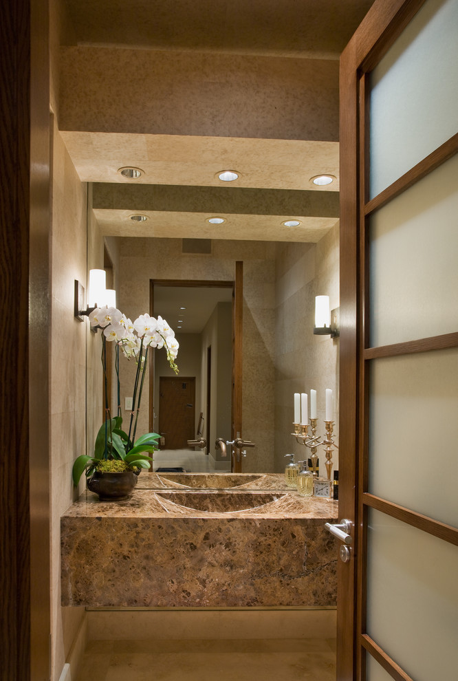 This is an example of a mid-sized contemporary powder room in Orange County with flat-panel cabinets, beige cabinets, beige tile, travertine, beige walls, travertine floors, a trough sink, granite benchtops and beige floor.