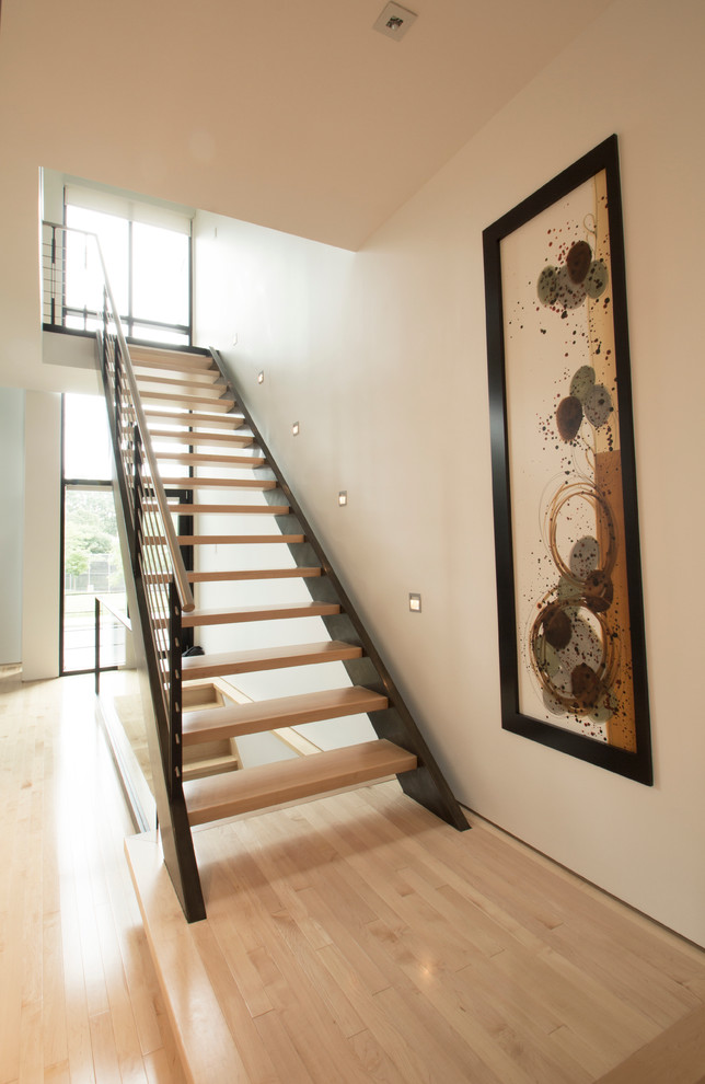 Inspiration for a mid-sized modern wood straight staircase in Montreal with metal risers.