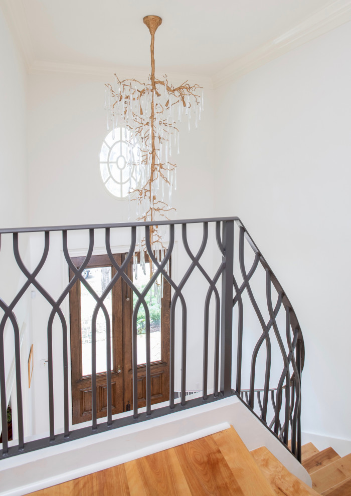 Example of a mid-sized transitional wooden curved metal railing staircase design in Austin with painted risers