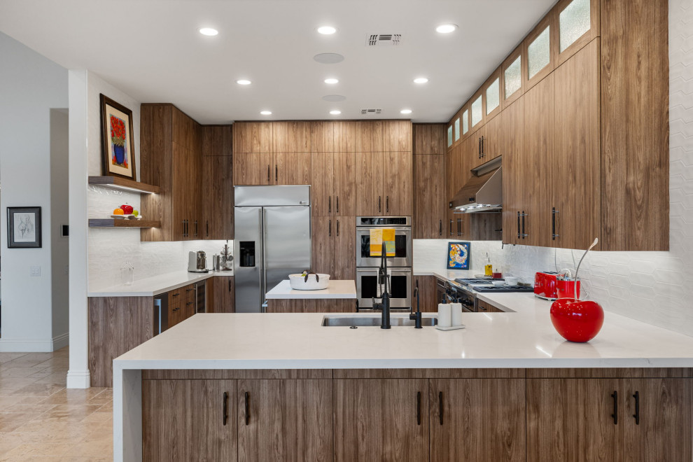 Mountain style l-shaped slate floor and beige floor enclosed kitchen photo with a single-bowl sink, flat-panel cabinets, medium tone wood cabinets, quartzite countertops, white backsplash, glass sheet backsplash, stainless steel appliances, a peninsula and white countertops