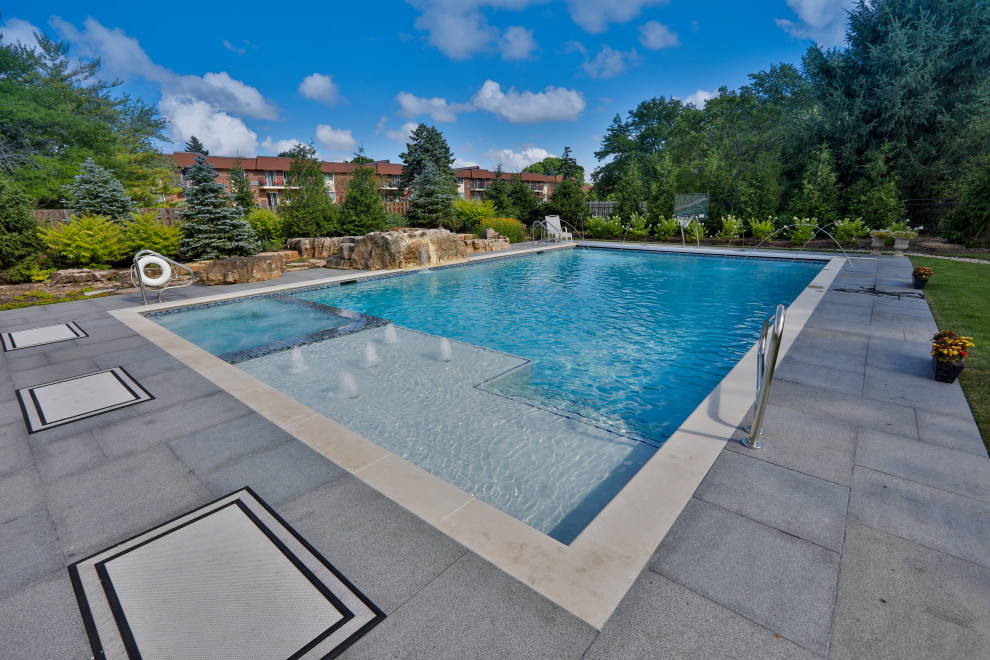 Design ideas for a mid-sized traditional backyard rectangular lap pool in Chicago with with a pool and natural stone pavers.