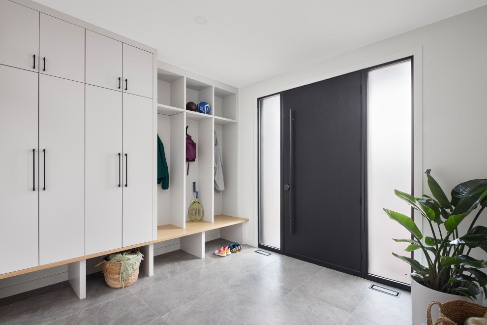 Transitional mudroom photo in Ottawa with white walls and a black front door