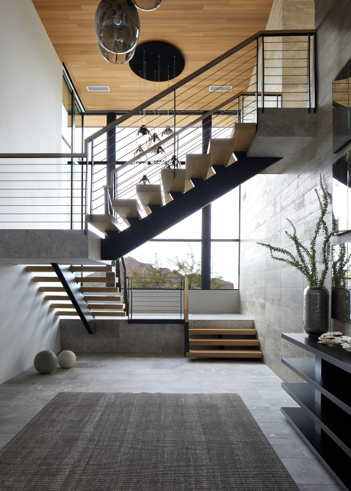 Imagen de escalera suspendida moderna extra grande con escalones de madera, contrahuellas de metal y barandilla de varios materiales