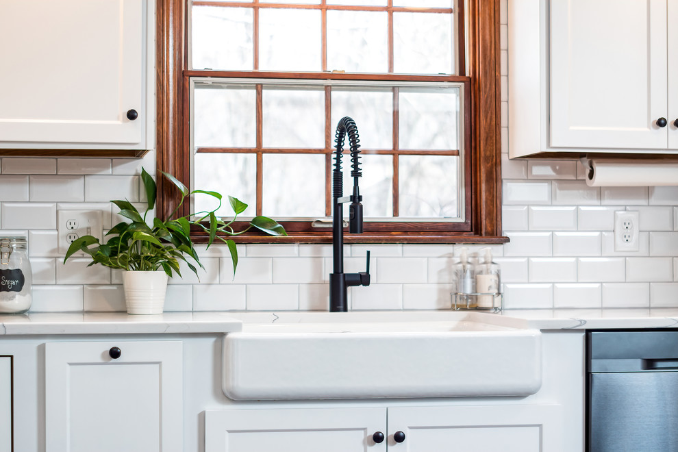 Example of a large transitional u-shaped eat-in kitchen design in Columbus with shaker cabinets, quartz countertops, white backsplash and an island