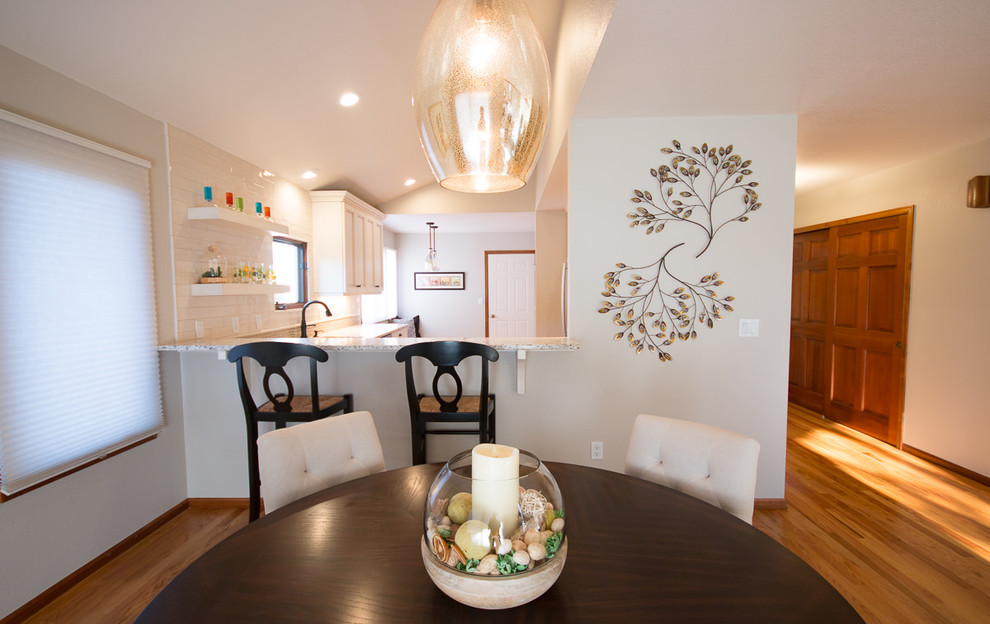 Transitional light wood floor and brown floor eat-in kitchen photo with an undermount sink, shaker cabinets, white cabinets, quartz countertops, white backsplash, ceramic backsplash and stainless steel appliances
