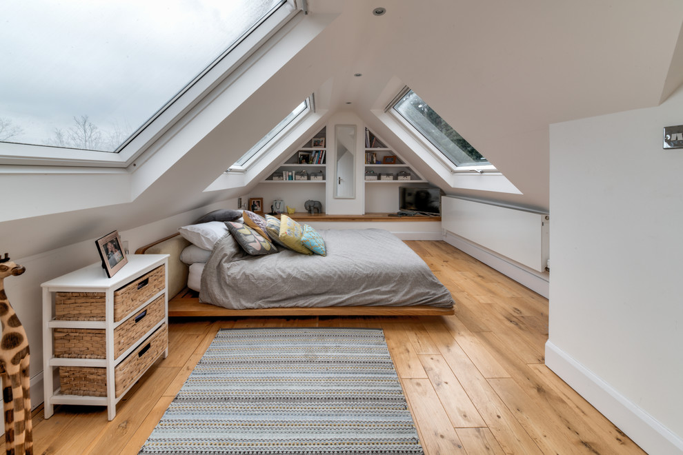 Photo of a large contemporary guest bedroom in London with white walls, medium hardwood floors and brown floor.
