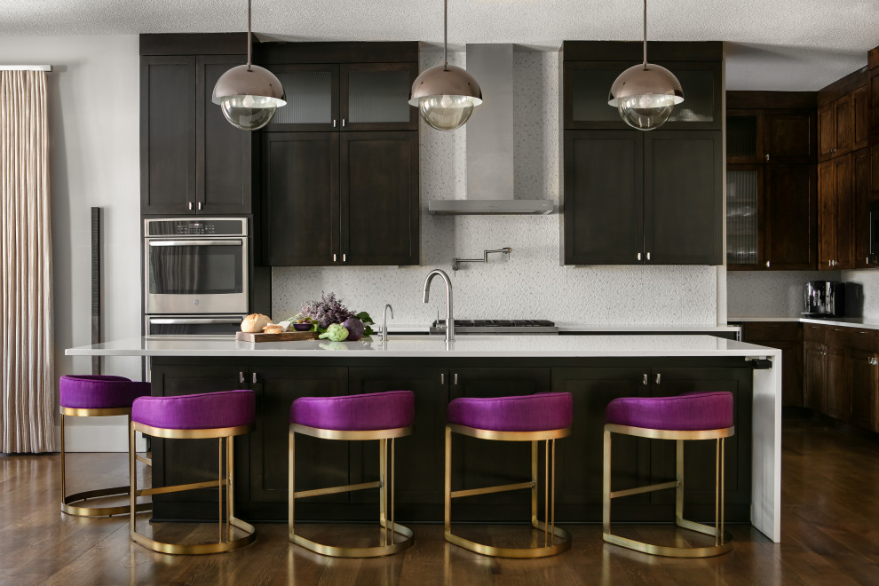 Kitchen - transitional medium tone wood floor kitchen idea in Kansas City with an undermount sink, black cabinets, white backsplash, stainless steel appliances, an island and white countertops