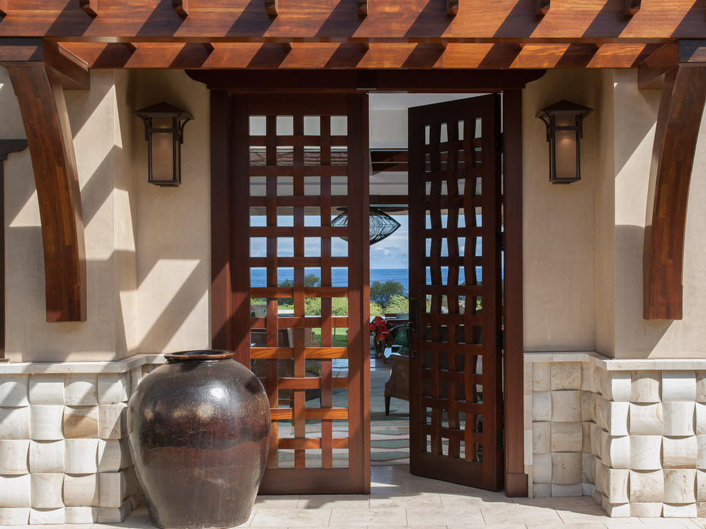 This is an example of a mid-sized tropical entryway in Hawaii with a double front door and a dark wood front door.