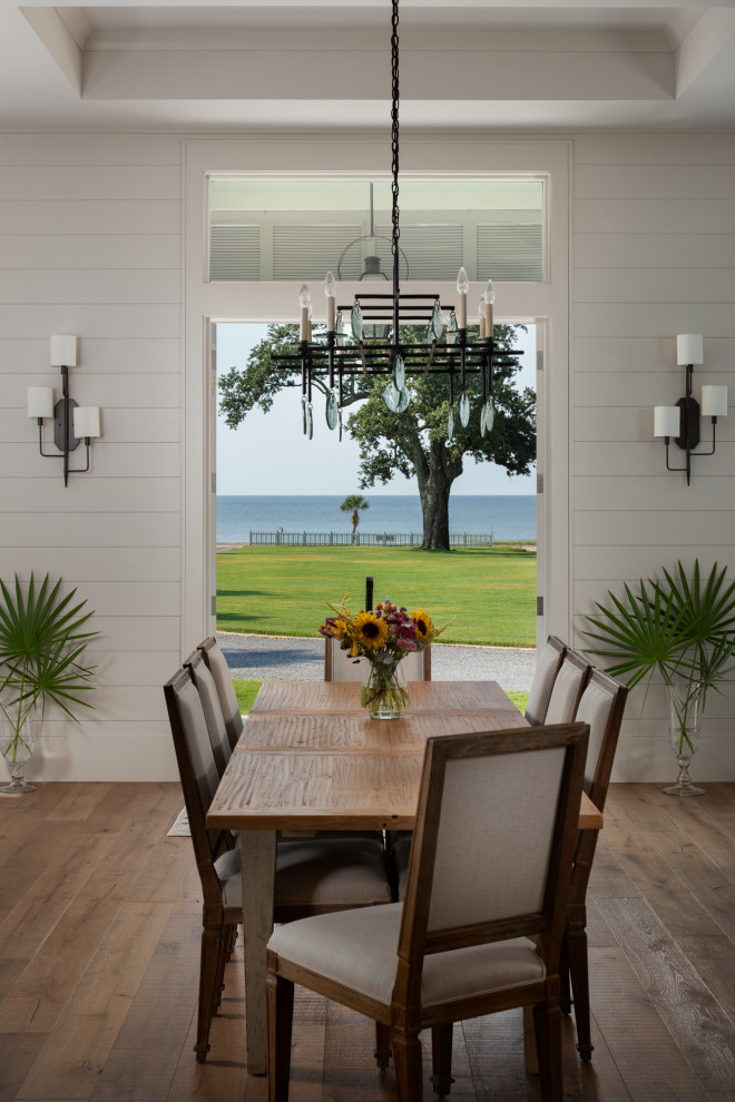 Inspiration for a large beach style open plan dining room in Birmingham with beige walls, medium hardwood flooring, a standard fireplace, brown floors, a coffered ceiling and tongue and groove walls.