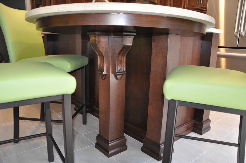 Example of a mid-sized transitional l-shaped ceramic tile eat-in kitchen design in Ottawa with an undermount sink, recessed-panel cabinets, dark wood cabinets, stainless steel appliances and an island